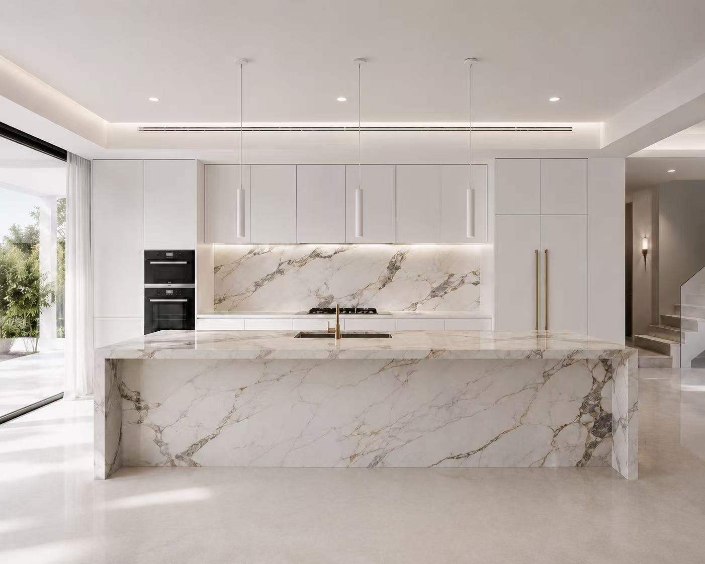White marble custom kitchen with large stone island and pendant lighting